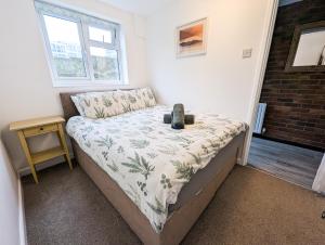 ein kleines Schlafzimmer mit einem Bett und einem Nachttisch in der Unterkunft South Fistral View Apartment in Newquay