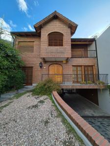 a brick house with a porch and a balcony at Chalet Tucumán in Bahía Blanca