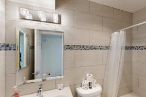 Un baño con lavabo, inodoro y espejo. en Slalom Run Mountain Home, en Sandpoint 18 fotos más