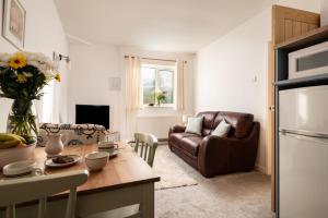 a kitchen and living room with a couch and a table at Horseshoe Cottage in Bridlington +6 photos