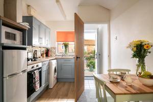 a kitchen with a table with a vase of flowers at Horseshoe Cottage in Bridlington