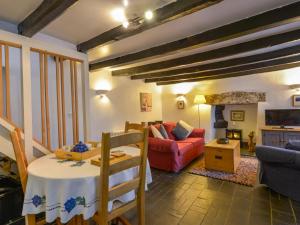 ein Wohnzimmer mit Tisch und Couch in der Unterkunft Churchgate Cottage in Bodmin