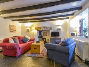 ein Wohnzimmer mit zwei Sofas und einem Kamin in der Unterkunft Churchgate Cottage in Bodmin