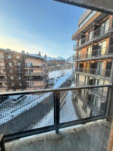 einen Balkon mit Blick auf eine Straße und Gebäude in der Unterkunft EVIS LTD apartments Gudauri in Gudauri