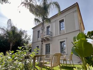 干尼亚Nearchou Boutique Hotel的房屋前设有椅子和桌子