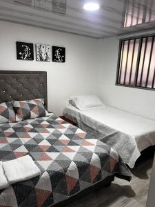 マニサレスにあるUn lugar acogedor y confortableのベッド2台と窓のある寝室
