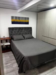 マニサレスにあるUn lugar acogedor y confortableのベッドルーム1室(大型ベッド1台、キャビネット付)