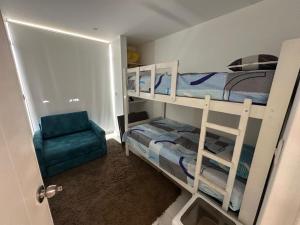 a small room with two bunk beds and a chair at Casa Playa en Aucallama Beach Club in Aucallama