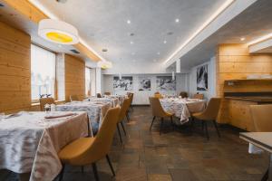 a restaurant with tables and chairs in a room at Sertorelli Sporthotel in Breuil-Cervinia