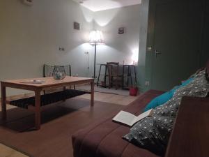 a living room with a table and a couch at Maison au cœur d'un petit village in Goutrens +13 photos