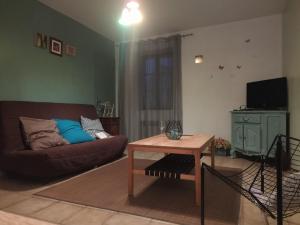 a living room with a couch and a table at Maison au cœur d'un petit village in Goutrens