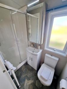 a bathroom with a toilet and a sink and a window at Griffiths Getaway in Pickering +1 photo