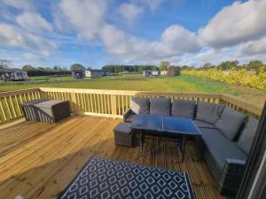 a patio with a couch and a table on a deck at Griffiths Getaway in Pickering