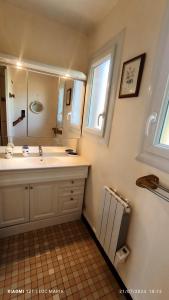 Un baño con lavabo, espejo y ventana. en Maison Martha, en Bangor