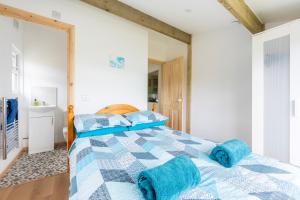a bedroom with a blue bed with blue towels on it at WestHill Beach Chalet, Riviere Towans in Hayle