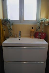 a white sink in a bathroom with two windows at Grande Terrasse Hyper-Centre Quiet & Cozy for 2 in Foix