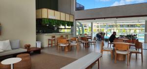a restaurant with tables and chairs and a person in the background at Porto de Galinhas - Muro Alto, Malia Beach Experience in Ipojuca