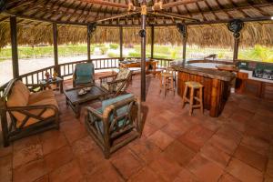 an outdoor patio with a bar and chairs and a table at Cabaña San Miguel in Moñitos