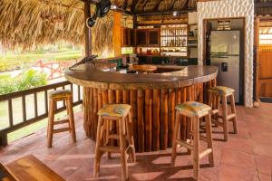 a bar in a kitchen with stools around it at Cabaña San Miguel in Moñitos