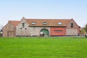 a large brick building with a green field in front of it at Suite & SPA à La Ferme 1802 in Sainghin-en-Mélantois