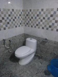 uma casa de banho com um WC branco numa parede em azulejo em Adam's Heaven em Alappuzha