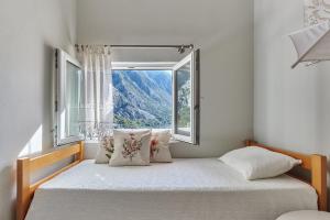 une chambre avec deux lits et une fenêtre dans l'établissement Helena Apartmani, à Kotor