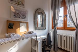 una camera con scrivania, specchio e asciugamani di La Tana di Mart - Zona Navigli - Vicino Metro a Milano