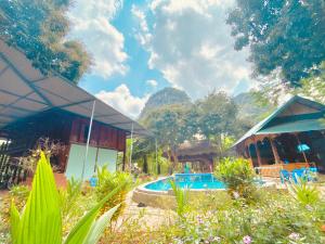 a resort with a swimming pool next to a building at Maison De Mai Hich in Mai Châu
