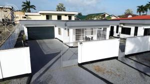a house with a gate and a garage at Nelly Residence in Paramaribo
