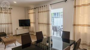a dining room with a table and chairs and a television at Nelly Residence in Paramaribo
