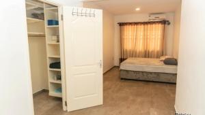 a bedroom with a door leading to a bed at Nelly Residence in Paramaribo