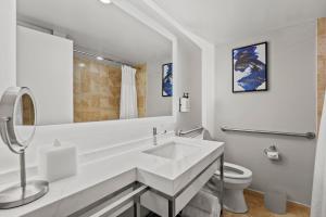 a white bathroom with a sink and a toilet at Crowne Plaza Orlando-Downtown by IHG in Orlando