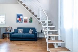 a living room with a blue couch and stairs at Casa Fossato in Bologna