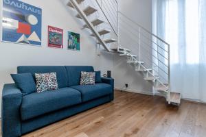 a blue couch in a living room with a staircase at Casa Fossato in Bologna
