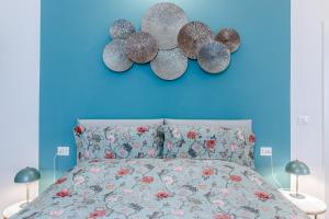 a blue bedroom with a bed and four fans on the wall at Casa Fossato in Bologna