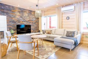 a living room with a couch and a tv at Villa Pyry in Vuokatti