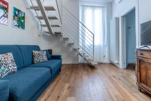 a living room with a blue couch and stairs at Casa Fossato in Bologna +27 photos