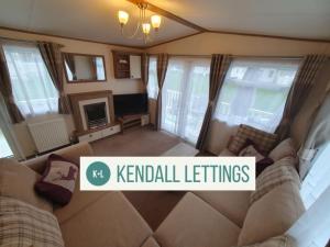 a living room with a couch and a tv at Elan in Selsey