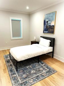 a bedroom with a bed with a rug and a window at Modern Luxury 3BR 2BA 10 minutes to NYC in Weehawken +2 photos