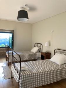 a bedroom with two beds and a window at Quinta Casa do Retiro in Penalva do Castelo