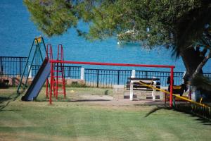 a park with a playground with the ocean in the background at By the sea in Hanioti +11 photos