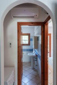 ein Badezimmer mit Waschbecken, Toilette und Spiegel in der Unterkunft Charming Le Dimore di Budoni 2 Bedroom Apt T6 in Budoni