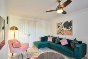 a living room with a green couch and a chair at Host & Stay - Cherry Blossom House in Launceston
