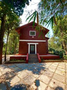 a red brick building with stairs in front of it at Sabera Heritage Homestay in Sakleshpur +13 photos