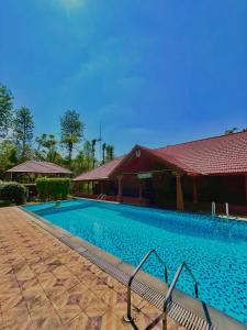 a large swimming pool next to a building at Sabera Heritage Homestay in Sakleshpur