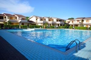 basen przed kilkoma budynkami mieszkalnymi w obiekcie Villaggio Loriana w Bibione