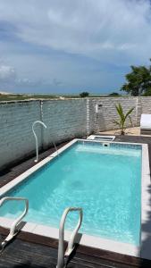 a large swimming pool with two chairs next to it at Casa Free Wind Jeri in Jericoacoara