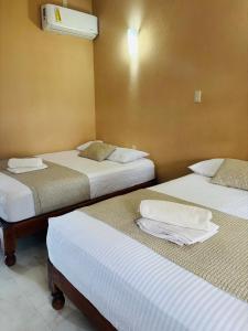 Un pat sau paturi într-o cameră la Hotel Rosa de los vientos
