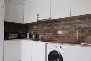 a kitchen with a washing machine and a sink at 9 min Metro to Downtown -Remote working - Free Parking in Porto +6 photos