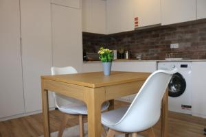 a kitchen with a wooden table and white chairs at 9 min Metro to Downtown -Remote working - Free Parking in Porto